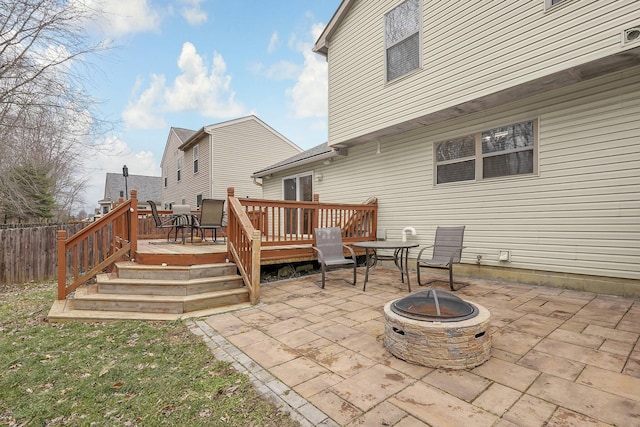 back of property with a wooden deck, a fire pit, and a patio area