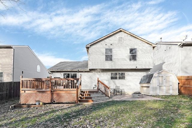 back of property featuring a patio, a deck, a fire pit, a yard, and a storage shed