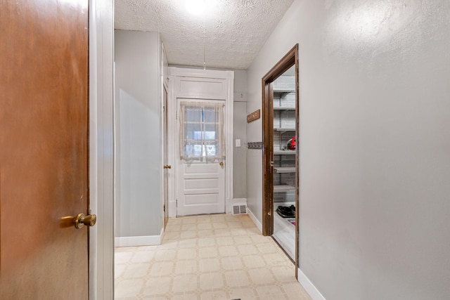 doorway with a textured ceiling