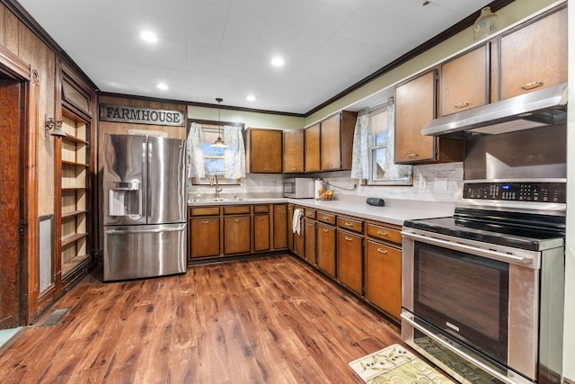 kitchen with sink, crown molding, tasteful backsplash, appliances with stainless steel finishes, and dark hardwood / wood-style flooring