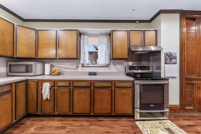 kitchen featuring dark wood-type flooring, ornamental molding, appliances with stainless steel finishes, and tasteful backsplash