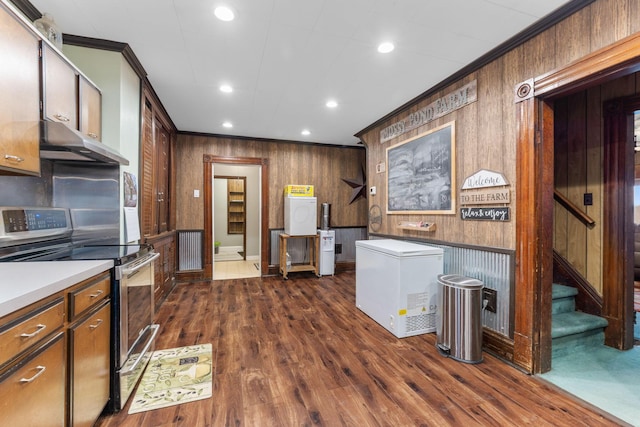 kitchen featuring crown molding, dark wood-type flooring, electric range, and refrigerator