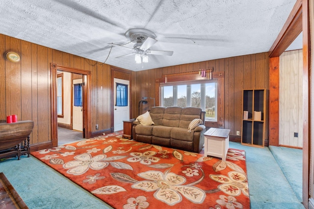 living room with carpet floors, a textured ceiling, and wood walls