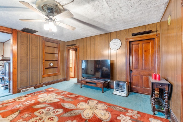 bedroom featuring wooden walls, light colored carpet, and a textured ceiling