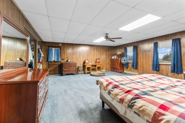 carpeted bedroom featuring a baseboard radiator, a drop ceiling, and ceiling fan