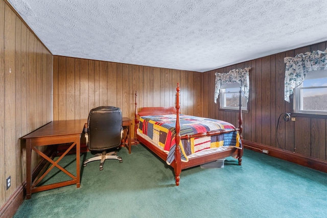 carpeted bedroom featuring a textured ceiling and wood walls