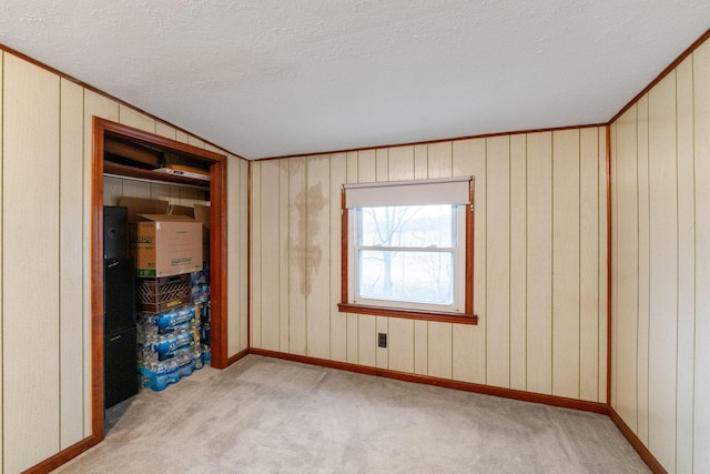 unfurnished bedroom with light carpet, crown molding, and a textured ceiling