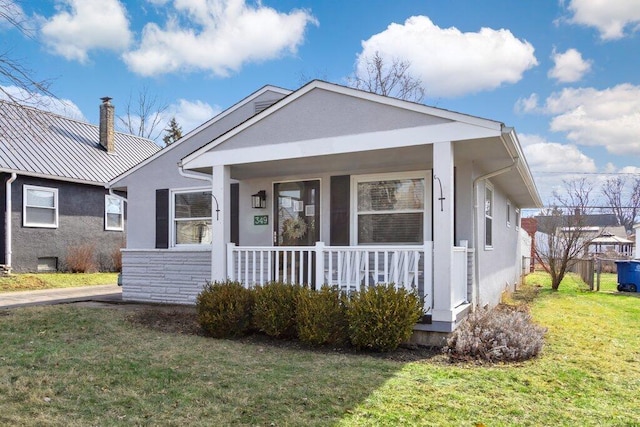 bungalow featuring a front yard and covered porch