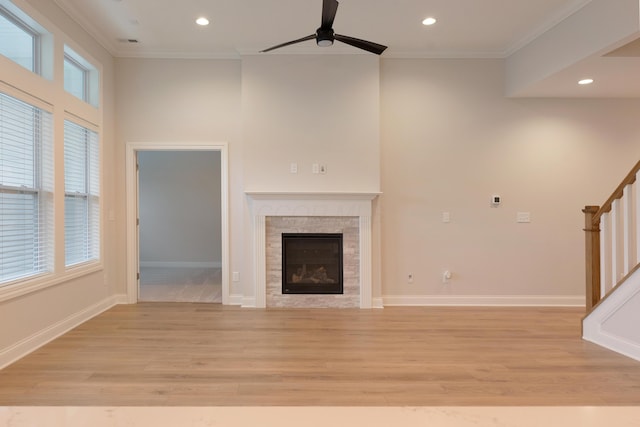 unfurnished living room featuring light hardwood / wood-style flooring, ornamental molding, and ceiling fan