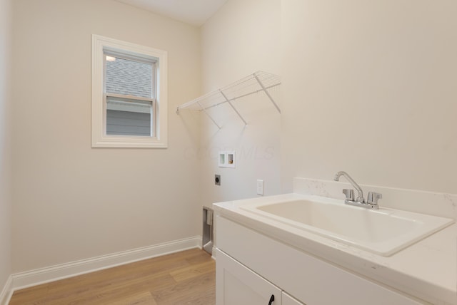 laundry room with sink, cabinets, light hardwood / wood-style floors, hookup for a washing machine, and hookup for an electric dryer
