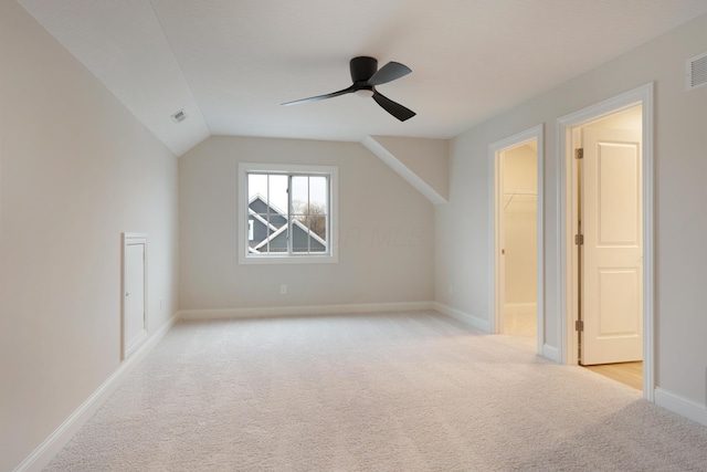 additional living space with vaulted ceiling, light carpet, and ceiling fan