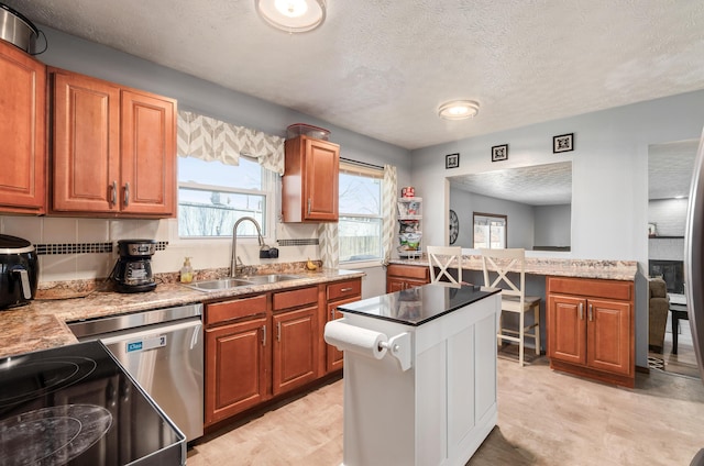 kitchen featuring brown cabinets, light countertops, and a sink