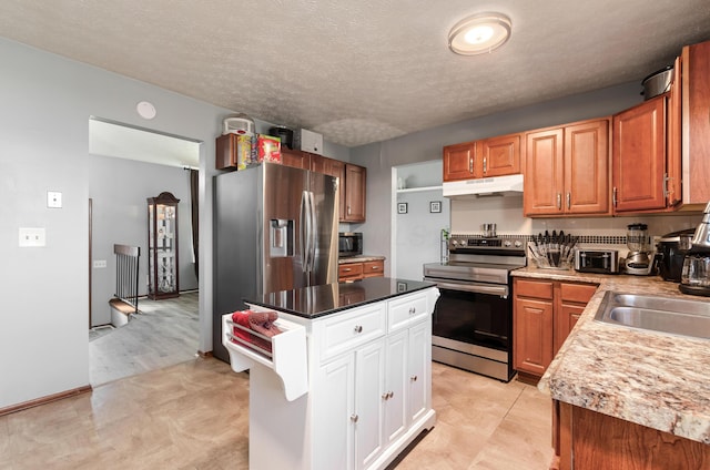 kitchen with under cabinet range hood, stainless steel appliances, a kitchen island, white cabinetry, and light countertops