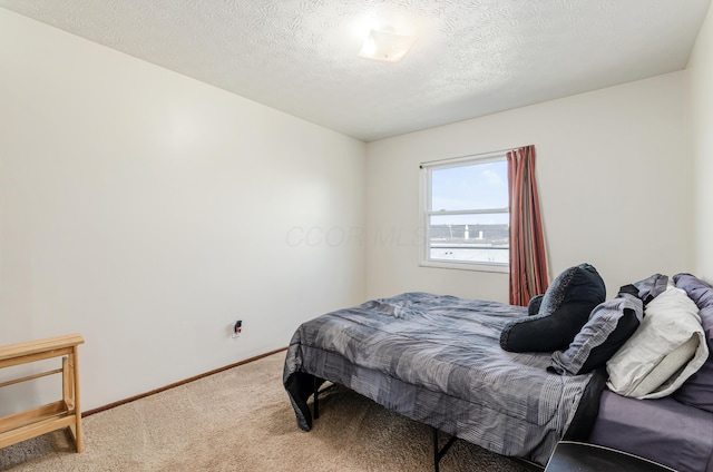 carpeted bedroom featuring a textured ceiling and baseboards