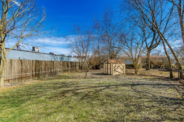 view of yard with a fenced backyard, an outdoor structure, and a shed