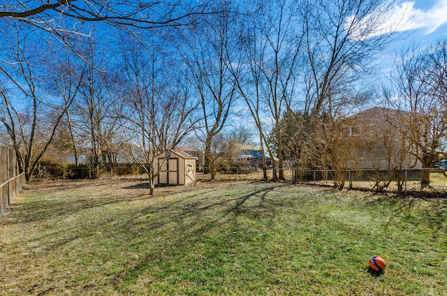 view of yard with an outbuilding, a fenced backyard, and a shed