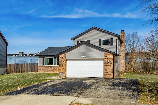 view of front facade with a garage, driveway, a chimney, fence, and brick siding