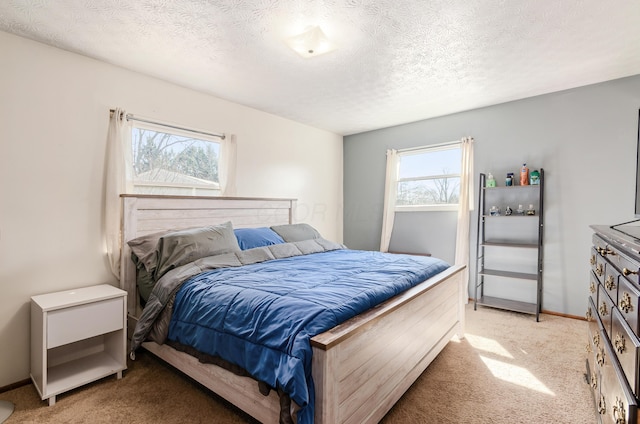 bedroom with light colored carpet, multiple windows, and a textured ceiling