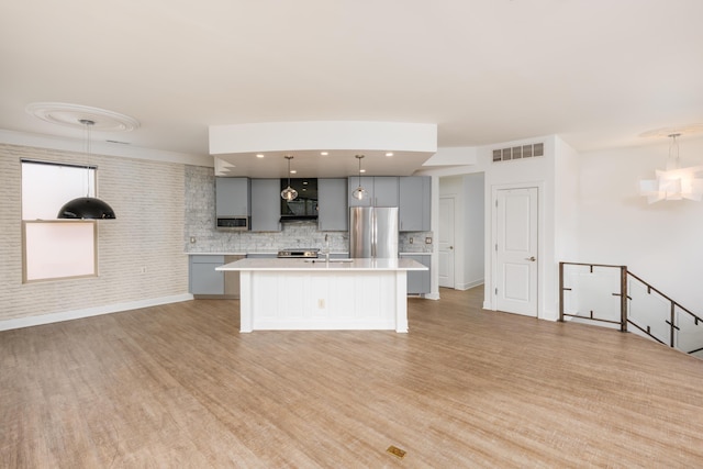 113 E Mithoff St, Columbus, OH 43206 - kitchen featuring freestanding refrigerator, gray cabinetry, light countertops, exhaust hood, and decorative backsplash