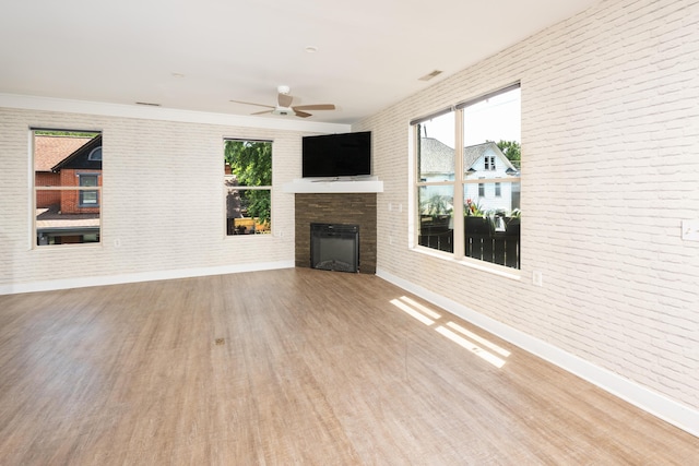 113 E Mithoff St, Columbus, OH 43206 - unfurnished living room with wood finished floors, brick wall, an outdoor fireplace, and ceiling fan