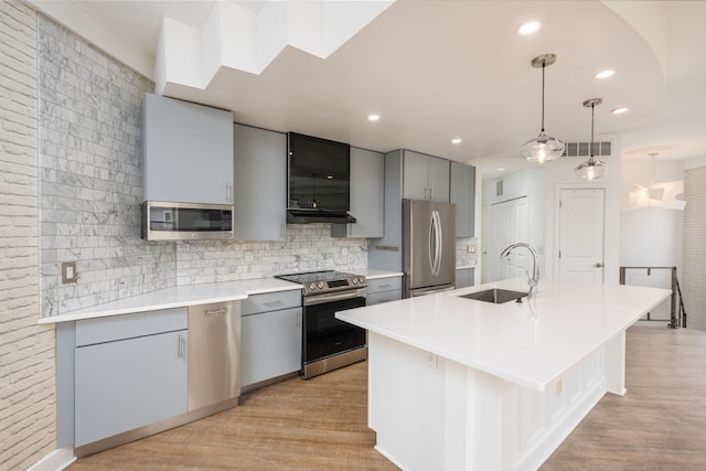 113 E Mithoff St, Columbus, OH 43206 - kitchen with stainless steel appliances, gray cabinets, tasteful backsplash, under cabinet range hood, and light countertops
