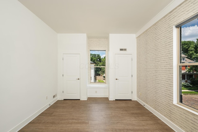 113 E Mithoff St, Columbus, OH 43206 - empty room with wood finished floors and brick wall