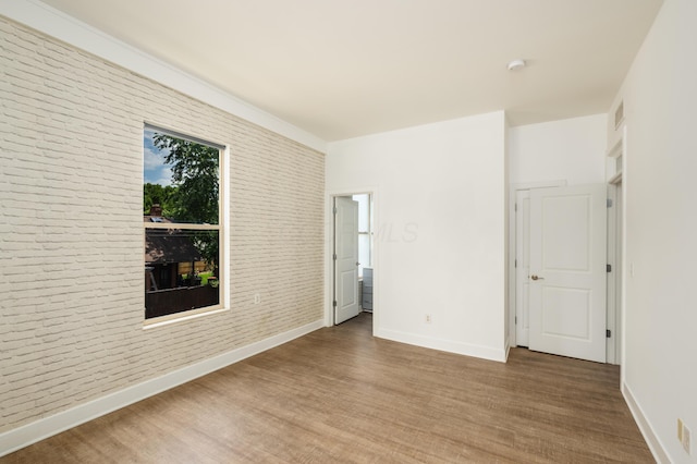 113 E Mithoff St, Columbus, OH 43206 - empty room featuring brick wall, wood finished floors, and a smoke detector