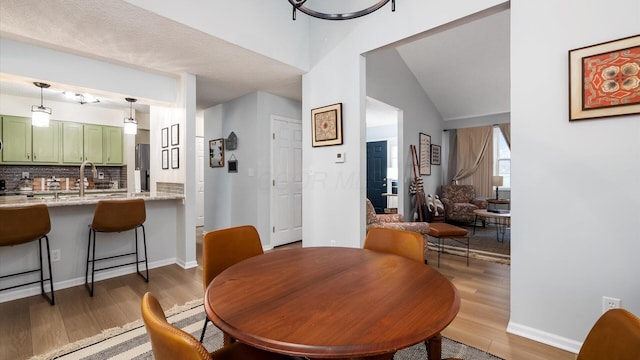 dining space with sink and hardwood / wood-style floors