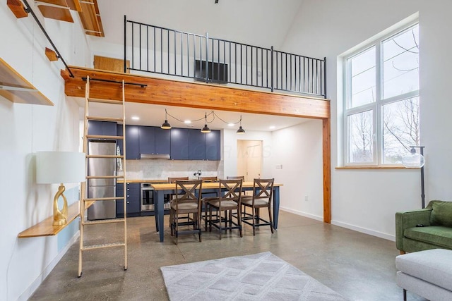 260 King St, Yellow Springs, OH 45387 - dining space featuring baseboards, a towering ceiling, concrete flooring, and a healthy amount of sunlight