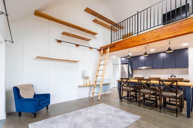 260 King St, Yellow Springs, OH 45387 - interior space with high vaulted ceiling, finished concrete flooring, hanging light fixtures, baseboards, and decorative backsplash