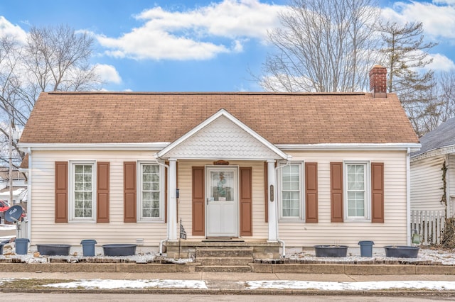 view of front of house with crawl space, a chimney, and roof with shingles