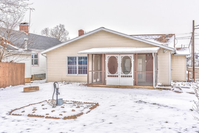 view of front facade with fence and a sunroom