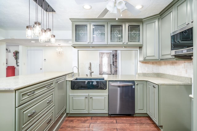 kitchen featuring glass insert cabinets, stainless steel appliances, hanging light fixtures, and a peninsula