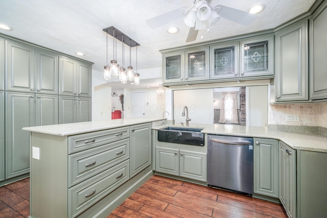 kitchen featuring light countertops, a peninsula, glass insert cabinets, and stainless steel dishwasher