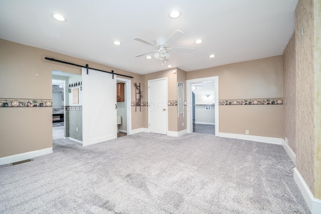 unfurnished room with baseboards, carpet floors, recessed lighting, and a barn door