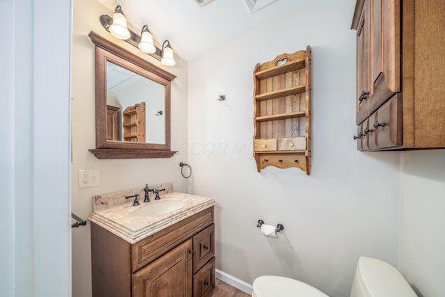 bathroom featuring vanity, toilet, and baseboards