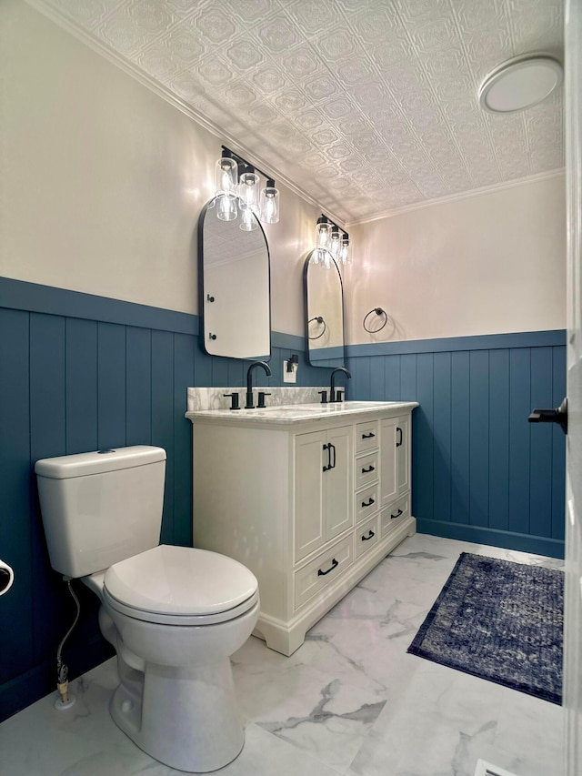 bathroom with crown molding, vanity, and toilet