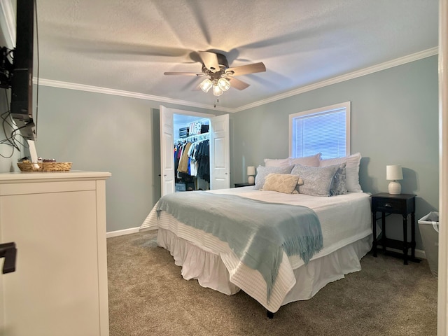 carpeted bedroom with a walk in closet, ceiling fan, crown molding, a textured ceiling, and a closet