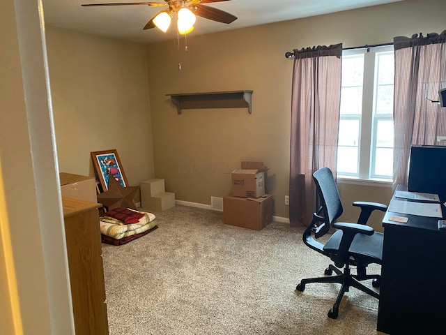 carpeted office space featuring ceiling fan