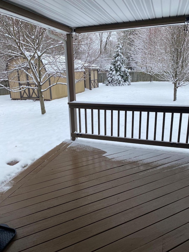 snow covered deck featuring a shed