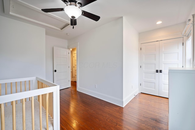 unfurnished bedroom featuring washer / dryer, hardwood / wood-style floors, and ceiling fan