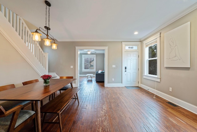 dining area with crown molding and dark wood-type flooring