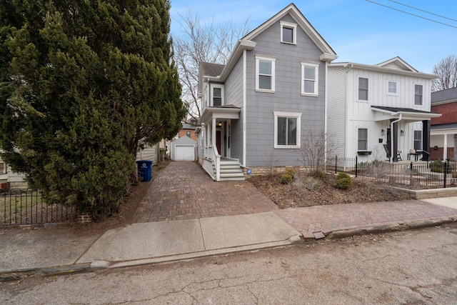 view of front of home featuring a garage and an outbuilding