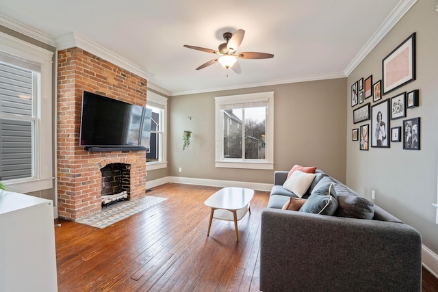 living room with hardwood / wood-style flooring, ornamental molding, and a fireplace