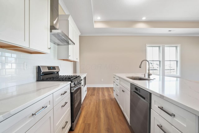 kitchen featuring dark wood-style flooring, appliances with stainless steel finishes, white cabinetry, a sink, and wall chimney range hood