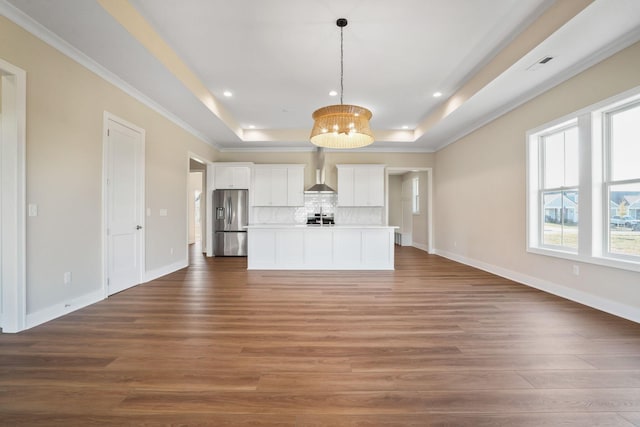 unfurnished living room featuring a tray ceiling, dark wood-style flooring, recessed lighting, and baseboards