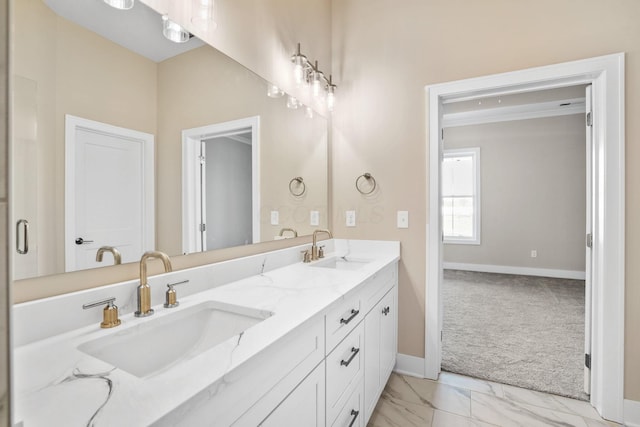 bathroom with marble finish floor, double vanity, a sink, and baseboards