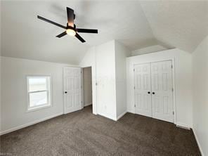 additional living space featuring ceiling fan, vaulted ceiling, and dark colored carpet