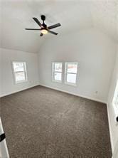 additional living space featuring lofted ceiling, dark carpet, and ceiling fan