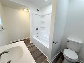 bathroom featuring wood-type flooring, tub / shower combination, and toilet